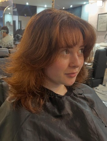 Copper messy cut with razored layers and a heavy fringe, photographed for the zine cover