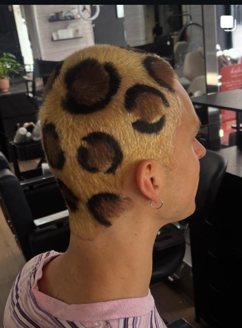 Bleached blonde hair with a shaved leopard-print stencil pattern